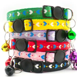 Close-up detail of colorful pet collars featuring cute heart patterns, buckles, and bells.