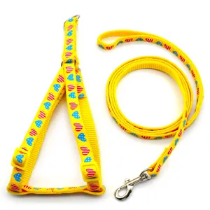 Yellow pet leash and harness detail showing lovely heart patterns and metal hardware.