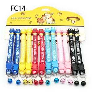 Colorful pet collar detail, woven strap with letters and metal bell for cats and dogs.
