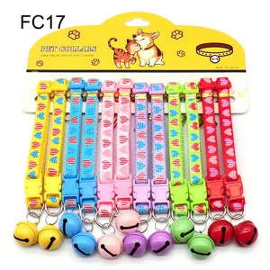 Detailed view of colorful pet collars with bells, plastic buckle and cute heart pattern.