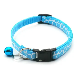 Nahaufnahme Detail des blauen Katzenhalsbands mit weißem Muster, Schnalle und kleiner Glocke.