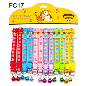 Colorful pet collar detail showing quick-release buckle, metal D-ring and hanging bell.