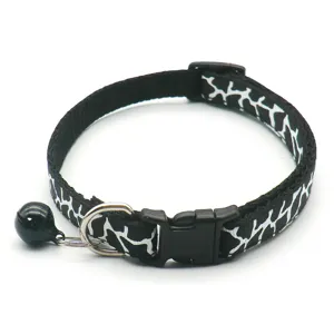 Nahaufnahme des schwarz-weiß gemusterten Katzenhalsband-Details mit Glocke und Schnalle.