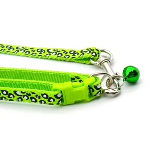 Gruenes Leo-Muster Haustier Leine Halsband Detail mit Nylonband, Plastikschliesse und Metallglocke.