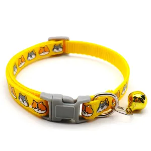 Yellow pet collar detail showing cute cartoon animal prints, grey plastic buckle and gold bell.