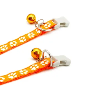 Orange pet collar with white paw print, bell, metal D-ring and plastic buckle, 1cm wide.