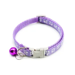 Detailed view of purple pet collar with white paw print, safety buckle and cute bell.