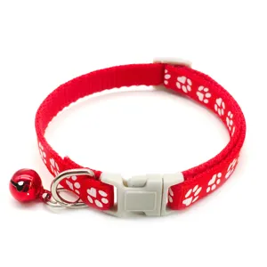 Red nylon pet collar detail close-up, featuring cute white paw prints and a red bell.