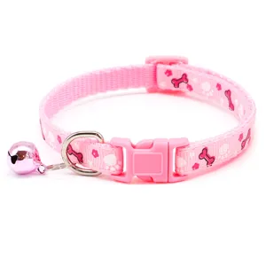 Rosa Haustierhalsband Detail mit niedlichen Knochen und Pfotenmustern, Schnalle und kleiner Glocke.