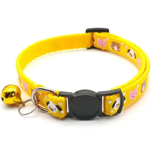 Close-up detail of yellow pet collar with cute cartoon animal prints, black buckle and golden bell.