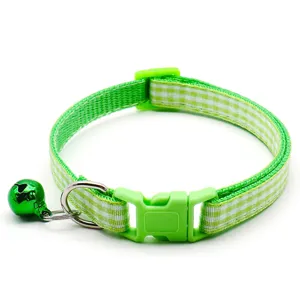 Detailed closeup of the green plaid pet collar featuring a cute bell and durable plastic buckle.