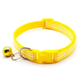 Detail view of yellow checkered pet collar featuring cute golden bell and secure buckle.