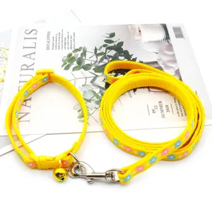Close-up of yellow pet leash and collar set with cute blue and pink flower prints for cats.