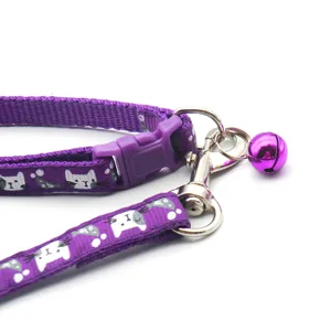 Detail view of purple pet collar and leash set with cute cat pattern and ringing bell.
