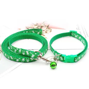 Green bone pattern pet collar and leash set detail shot featuring metal hook and bell.