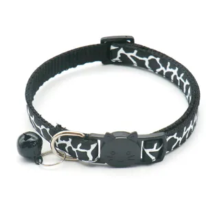 Detailed view of black and white printed pet collar with cat face buckle and bell.