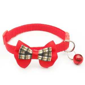 Detail van rood huisdierenhalsband met geruite strik en bel voor katten en honden.