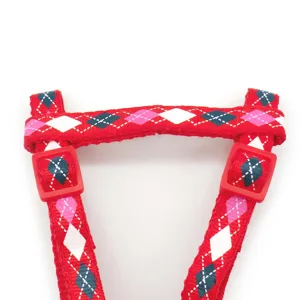 Close-up detail of the red argyle pattern pet harness strap with durable red plastic buckle.