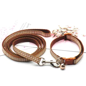 British style brown plaid pet leash and collar set with bell for cats and dogs walking outdoors.