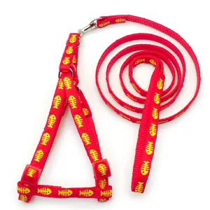 Red pet harness and leash set with yellow fish bone print detail shot displaying product quality.
