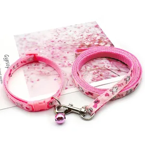 Close-up detail of pink pet leash and collar set featuring cute rabbit prints and metal bell.