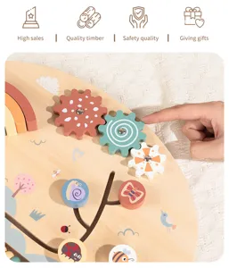 Wooden rainbow busy board detail showing colorful gears and interactive infant toy elements.