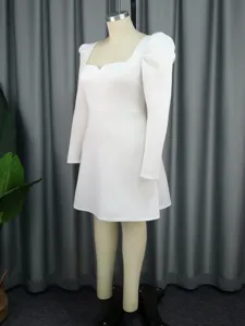 Weißes Langarmkleid mit eckigem Ausschnitt Detail zeigt elegantes Design und glatten Stoff.