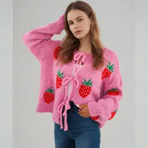 Roze gebreide aardbeien cardigan met ronde hals, lange mouwen en striksluiting vooraan.