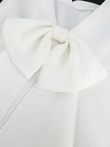 Weißes Damen Kleid Detail Nahaufnahme mit elegantem großen Schleife und quadratischem Ausschnitt.