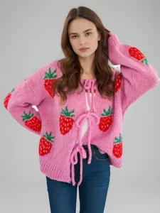 Close-up detail van het roze aardbeien breiwesten met leuke strikbandjes en lange mouwen.
