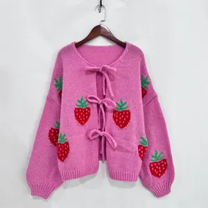 Roze gebreid damesvest met schattig aardbeienpatroon, lange mouwen en mooie strikjes.