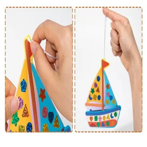 Close-up details of children's DIY mosaic craft sailboat toy with colorful sparkly stickers.