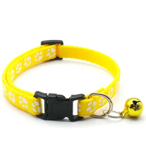 Vue détaillée du collier pour animal de compagnie jaune avec des empreintes et cloche pour chiens.