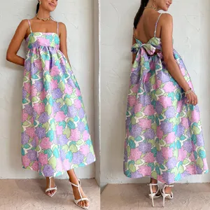 Vue détaillée montrant l'imprimé floral et le nœud dos nu de la robe longue d'été.