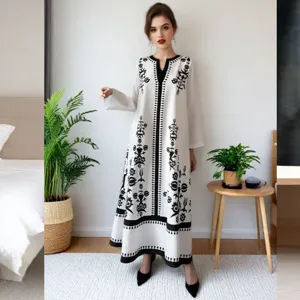 Elegant resort style black and white floral print long dress with V-neck and long sleeves.