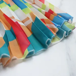 Close-up of colorful geometric pleated chiffon fabric detail showing texture and hem.