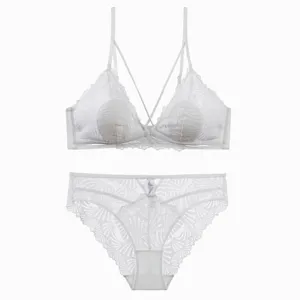 Detailaufnahme des weißen Spitzen-Lingerie-Sets mit filigranen Blumenmustern und gekreuzten Trägern.