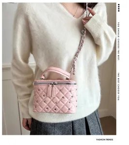 Pink quilted mini vanity bag detail showcasing metal studs and chain strap design.