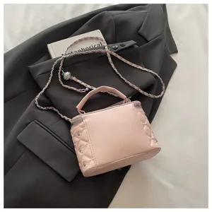 Detailed view of the elegant pink quilted mini box handbag featuring a chic chain strap.