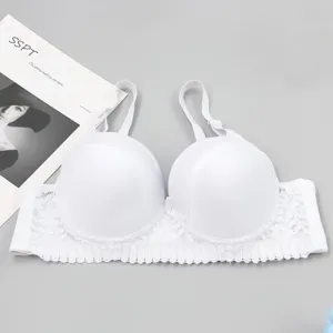 Close-up of white padded push-up bra with delicate lace trim and smooth cups detail.