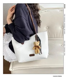Stylish commuter shoulder bag for women, elegant white texture design with chic pendant.