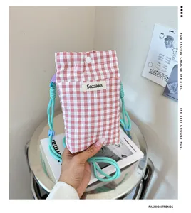Close-up detail of the pink and white checkered phone pouch, showcasing fabric texture and strap.