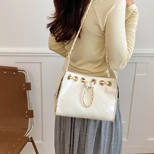 Stylish white quilted bucket bag with gold chain strap and chic drawstring design.