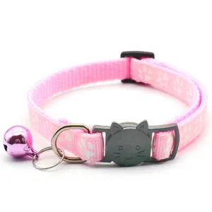 Detailopname van roze huisdierenhalsband met pootafdrukken, kattengesp en glimmende bel.