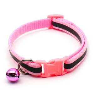 Detail view of pink reflective pet collar showing black stripe, safety buckle and cute bell.