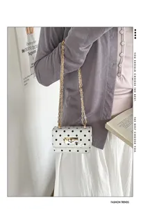 Chique witte schoudertas met stippen en gouden ketting, stijlvol zomer modeaccessoire.