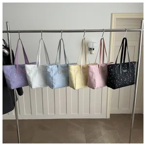 Chique shopper tassen met sterrenmotief in zes verschillende kleuren aan een rek getoond.