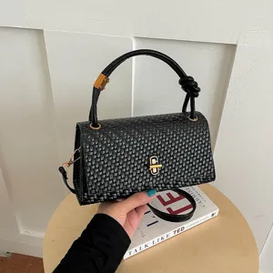 Black woven handbag with knot handle and metal lock. Elegant shoulder bag for women.