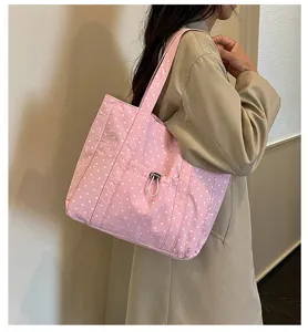 Vue détaillée du sac cabas en toile à pois rose avec poche cordon de serrage avant.