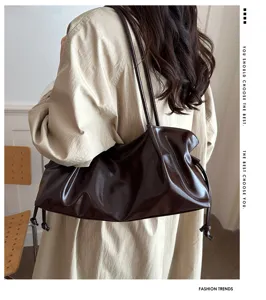 Detail view of the dark brown pleated shoulder tote bag with elegant glossy leather finish.